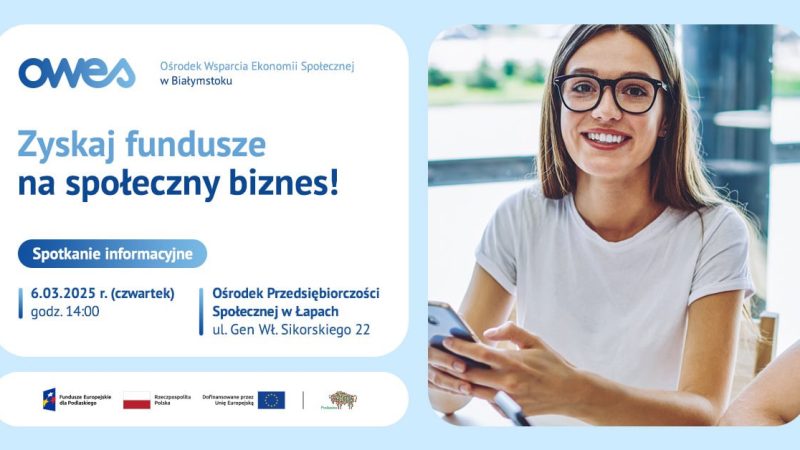 Uśmiechnięta młoda kobieta w okularach siedzi trzymając w ręku telefon.